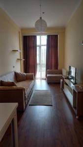 a living room with a couch and a tv at Natia rooms in Tbilisi City