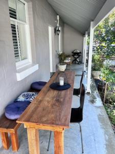 drewniany stół i krzesła na ganku w obiekcie Penzance Cottage w mieście Adelaide