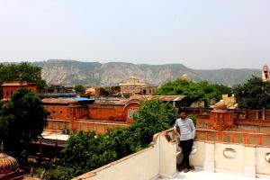 Człowiek stojący na szczycie ściany patrzący na miasto w obiekcie Friend India w mieście Dżajpur