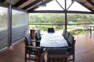 a dining room with a table and chairs on a deck at Strath Creek Station farm-stay in Strath Creek