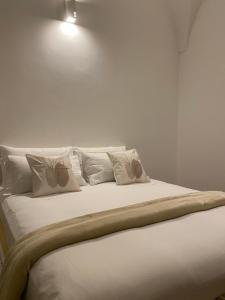 łóżko z białymi poduszkami i lampką na ścianie w obiekcie LA CASA DI SASA' w mieście Maiori