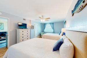 a bedroom with two beds and a ceiling fan at Castaways 8C in Gulf Shores