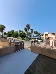 a balcony with a view of a street with palm trees at Nice bungalow La Mata with sea views in Torrevieja