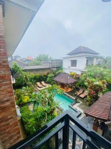 uitzicht op een zwembad vanaf een balkon van een huis bij Nami House in Ubud