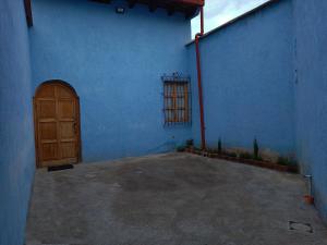a blue building with a wooden door and a window at Casa Aguacate in Antigua Guatemala