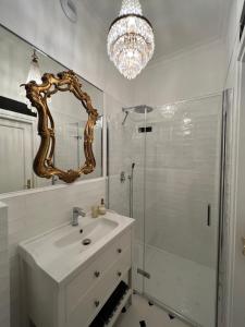 y baño con lavabo y ducha con espejo. en Supreme Apartment en Cracovia