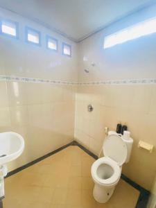 a bathroom with a toilet and a sink at Nami House in Ubud