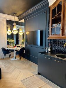 cocina con fregadero y mesa con sillas en Supreme Apartment en Cracovia
