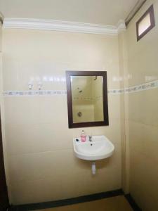 a bathroom with a sink and a mirror on the wall at Nami House in Ubud