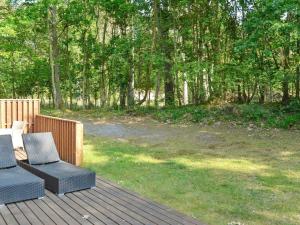 2 sillas y una mesa en una terraza de madera en 10 person holiday home in Hasle, en Hasle