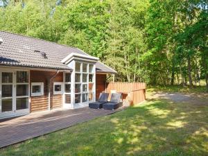 a wooden deck with two chairs on a house at 10 person holiday home in Hasle in Hasle