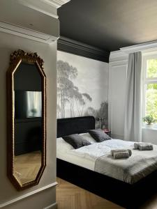 1 dormitorio con espejo grande y cama en Supreme Apartment en Cracovia