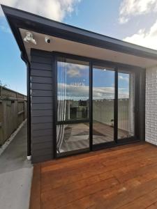 a house with a large window on a deck at Paradise Retreat in Tauranga