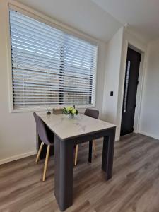 a dining room with a table and chairs and a window at Paradise Retreat in Tauranga