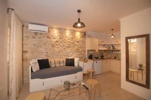 Un dormitorio con una cama y una pared de piedra. en The Monastery Apartment, en Corfú