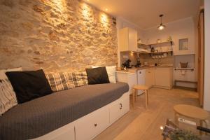 1 dormitorio con pared de piedra, 1 cama y cocina en The Monastery Apartment, en Corfú 13 fotos más