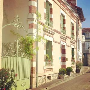 a building with a gate on the side of a street at Le 1930, chambres d’hôtes de charme in Cosne-Cours-sur-Loire