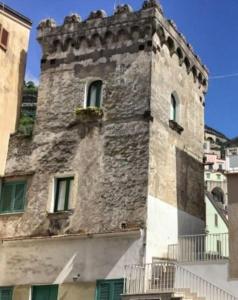a tall stone building with a window at La Torre in Maiori