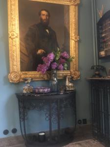 コーヌ・クール・シュル・ロワールにあるLe 1930, chambres d’hôtes de charmeの花のテーブルの上の男絵