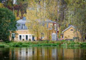 a house sitting next to a body of water at Villa Kingfisher in Åminnefors
