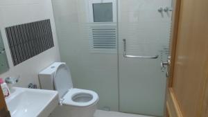 a bathroom with a toilet and a shower and a sink at Baran Homestay in Muscat