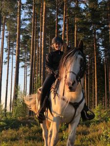 a young girl riding on a horse in the woods at Countryside Holiday home "Our Little Farm" in Hagfors