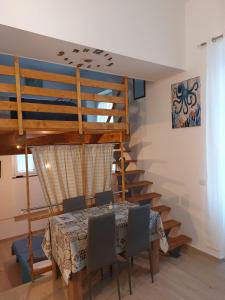 ein Esszimmer mit einem Tisch und einer Holztreppe in der Unterkunft Home & Bed Spartano in Sapri
