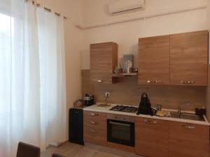 a small kitchen with a stove and a sink at Home & Bed Spartano in Sapri