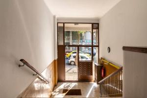 einen Flur mit einer Treppe, die zu einer Glastür führt in der Unterkunft Leon Cozy Apartment in Athen