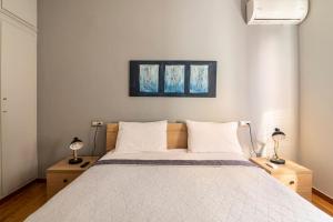 ein Schlafzimmer mit einem großen Bett mit zwei Lampen in der Unterkunft Leon Cozy Apartment in Athen