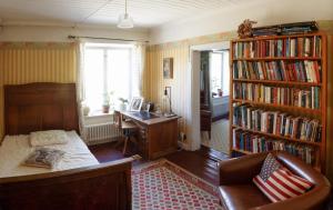 a room with a desk and a book shelf with books at Villa Kingfisher in Åminnefors