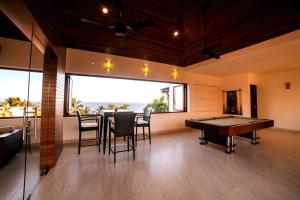 a room with a ping pong table and chairs in it at Super casa, la mejor vista de Huatulco in Tangolunda