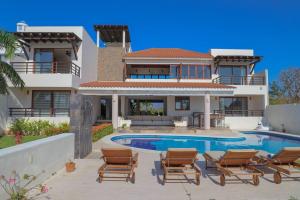 a villa with a swimming pool in front of a house at Super casa, la mejor vista de Huatulco in Tangolunda