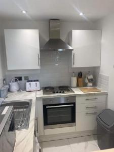 a kitchen with white cabinets and a stove top oven at Hermon chapel. in Wrexham