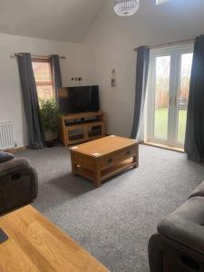 a living room with a television and a coffee table at Hermon chapel. in Wrexham