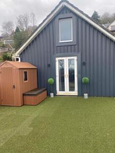 a blue building with two potted plants in a yard at Hermon chapel. in Wrexham