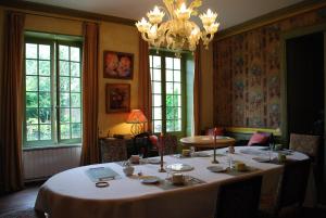 a dining room with a table and a chandelier at Le Ragois in Richelieu