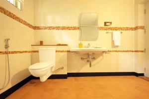 a bathroom with a toilet and a sink at Yercaud Bungalow Stay in Yercaud +16 photos