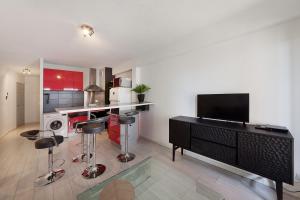 sala de estar con TV y cocina en Aka Appart'Hotel " Le Petit Coin de Lavaur", en Lavaur