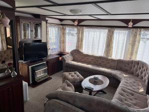 a living room with two couches and a television at Domki Delux w Helu in Hel