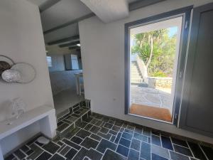 a bathroom with a window and a tile floor at Ergina Studios in Ios Chora