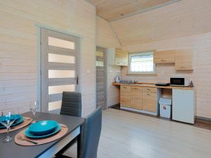 a kitchen and dining room with a table and chairs at Domki Malibu in Rusinowo