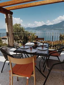 una mesa y sillas con vistas al océano en Agriturismo Le Anze en Torri del Benaco