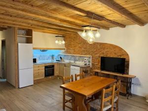 a kitchen with a wooden table and a white refrigerator at Casa Vicent in Alcanar