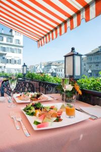 Storchen Zürich - Lifestyle boutique Hotel في زيورخ: طاولة مع طبقين من الطعام في الأعلى