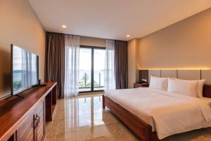 a bedroom with a large bed and a flat screen tv at Otres Beach Hotel in Sihanoukville