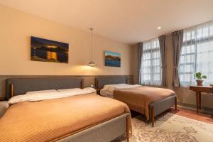基隆的住宿－安樓文旅Enzo House，酒店客房设有两张床和窗户。