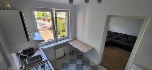 uma pequena cozinha com uma janela e um sofá em Szpitalna 9c em Suwałki