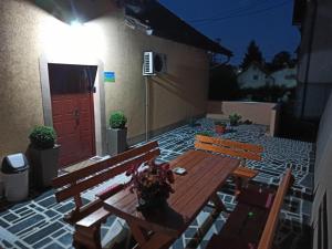 patio con mesa de madera, bancos y puerta en Kuća za odmor La Mia Casa, en Doboj