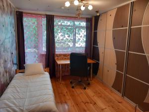 a bedroom with a bed and a desk and a window at Dzintari in Jūrmala